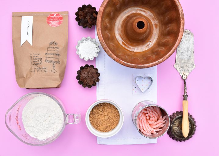 Wundertüte für Backfeen mit Flatlay Backutensilien auf rosa Untergrund