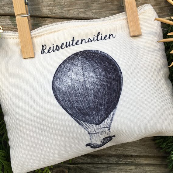 Reiseutensilien Kosmetiktasche auf Wäscheleine, cremefarben mit schwarzem Heißluftballon