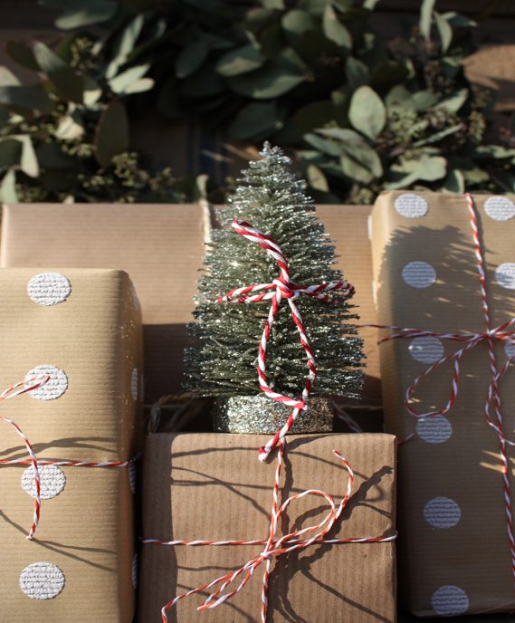 Geschenke und Tannenbaum mit Schleifen verschnürt und gestapelt