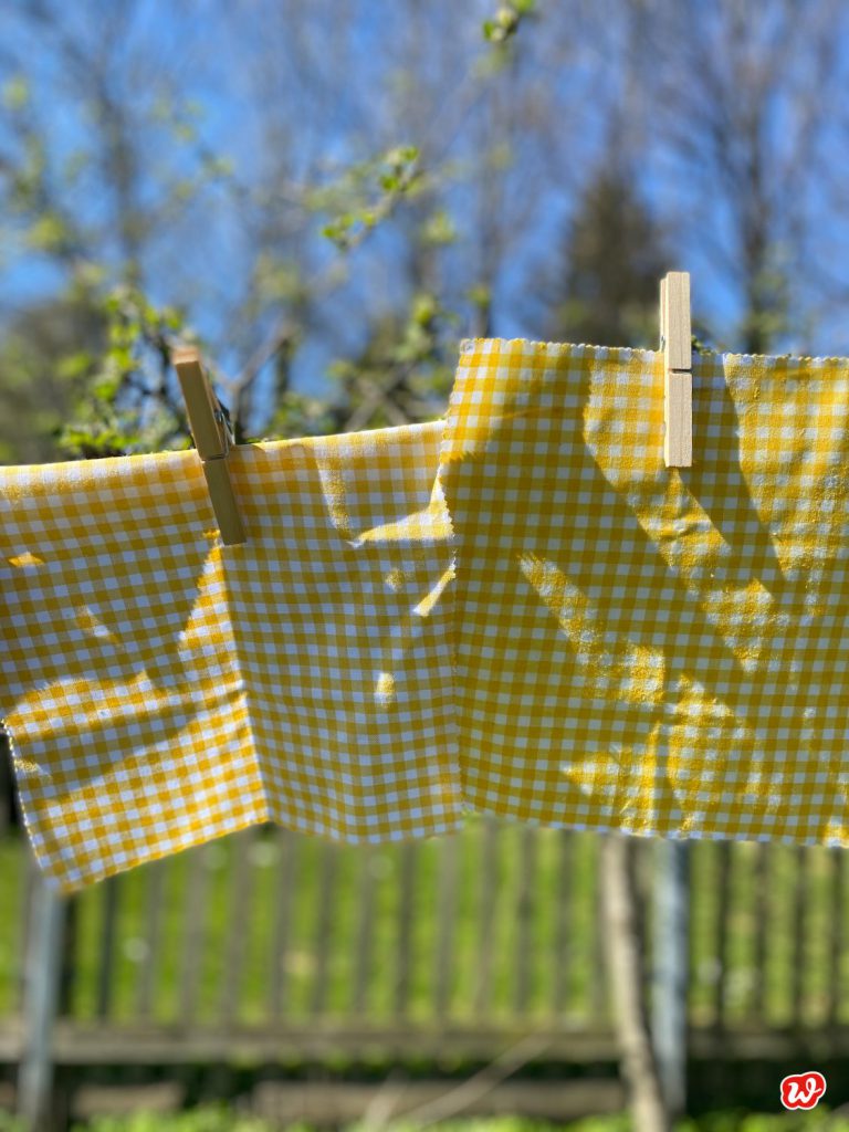 Gelb- weiß karierte Wachstücher auf Wäscheleine