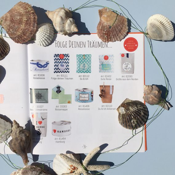 Wunderle_Katalog aufgeschlagen mit Reiseartikeln und Muschelkette