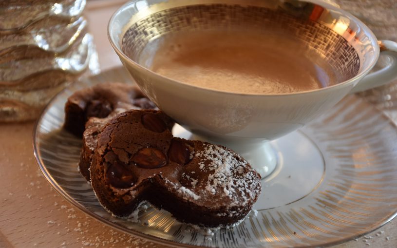 Vergoldete Kaffeetasse mit Pilzplätzchen in gemütlichem Licht