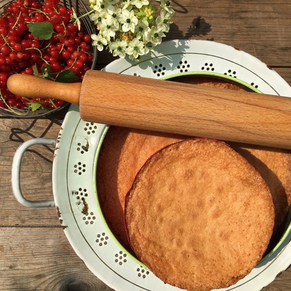 Kuchenböden mit Nudelholz auf weißem Durchschlag