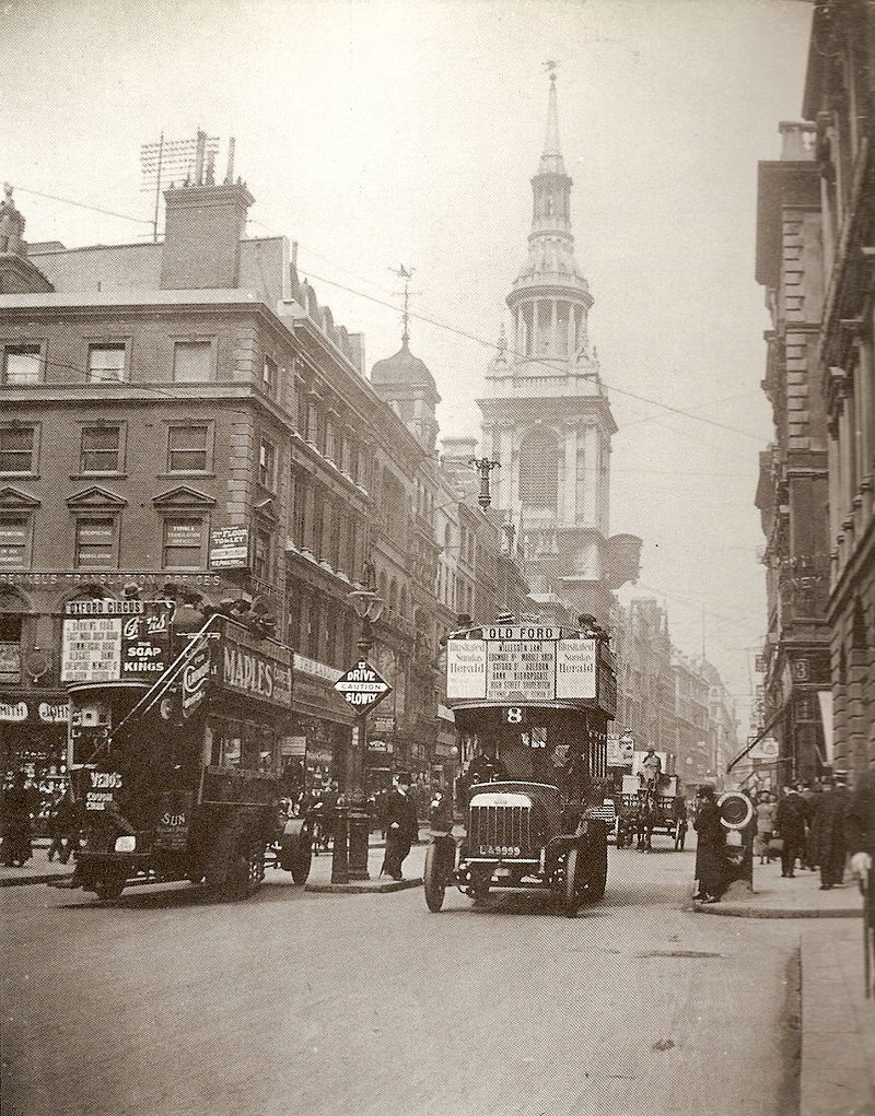 black and white photograph of a city in 1909 with cars and buildings