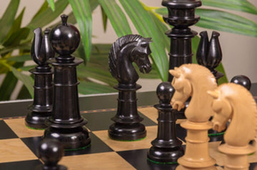 Slender chess set in black ebony and natural boxwood face off in close-up
