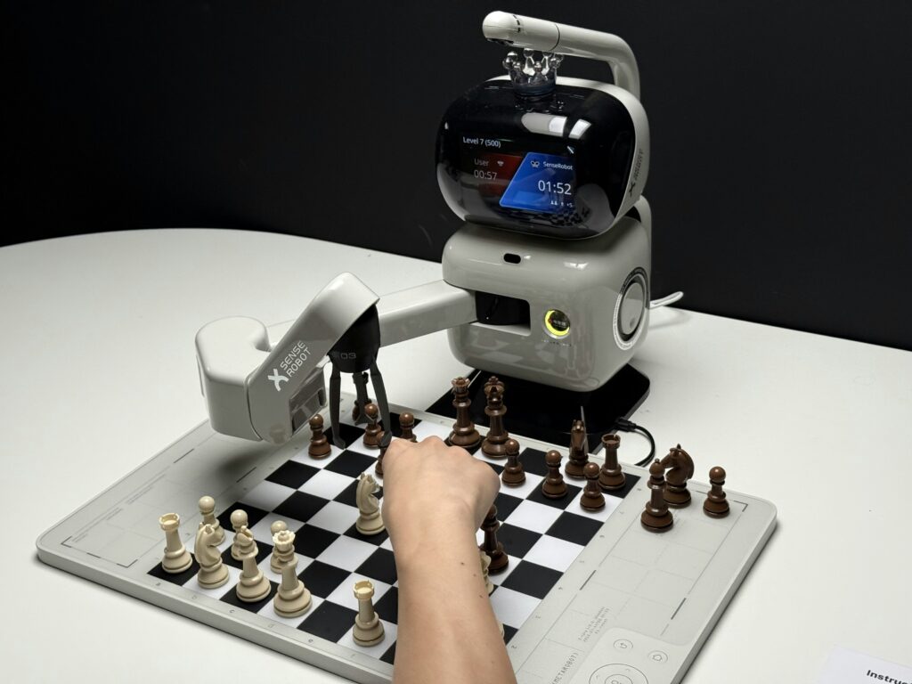 A photograph of a chess playing robot and electronic chess board.