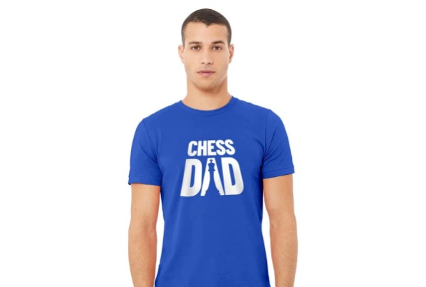A man with short hair is wearing a blue t-shirt with a "Chess Dad" logo on it