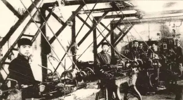Workers in the photo are operating a belt lathe