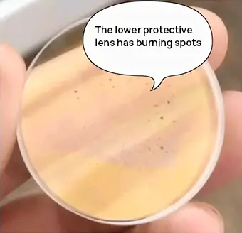 Aparecen puntos negros. Puntos de quemaduras en la lente protectora inferior del cortador láser.