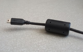 Imagen de una perla de ferrita utilizada en un cable de datos.