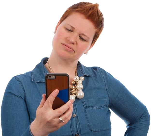 A woman is looking at her phone with a disgusted expression