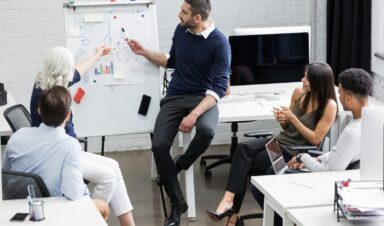 Creative people sitting at table in boardroom - Como ser um bom lider