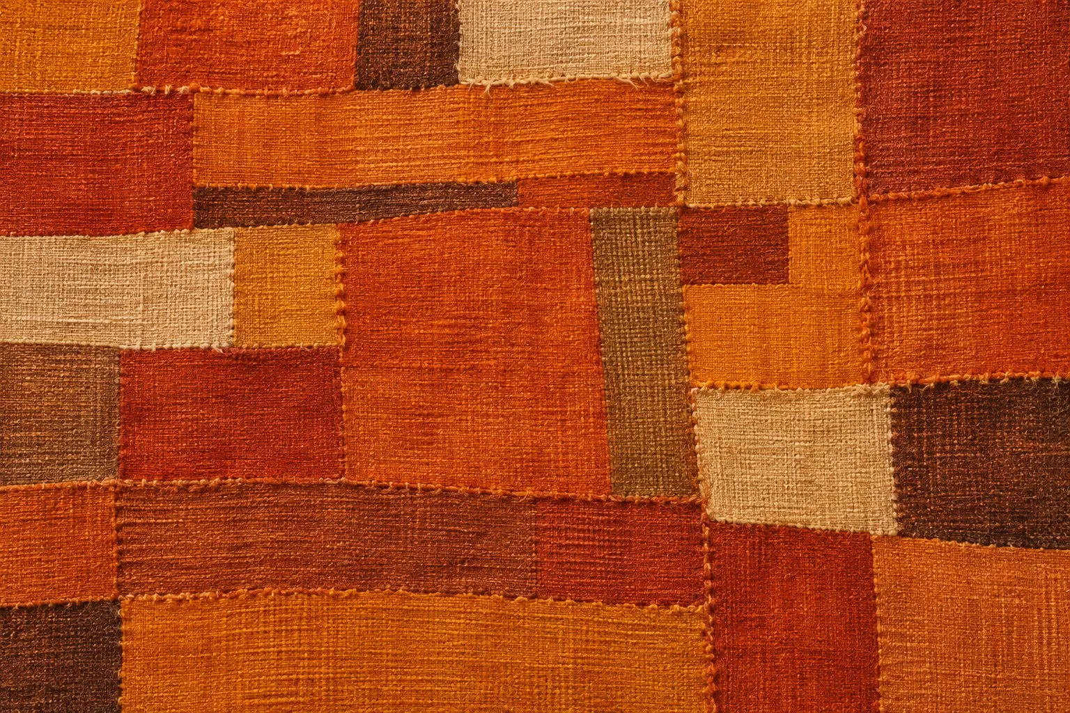 A patchwork of hand-dyed orange and ochre textiles