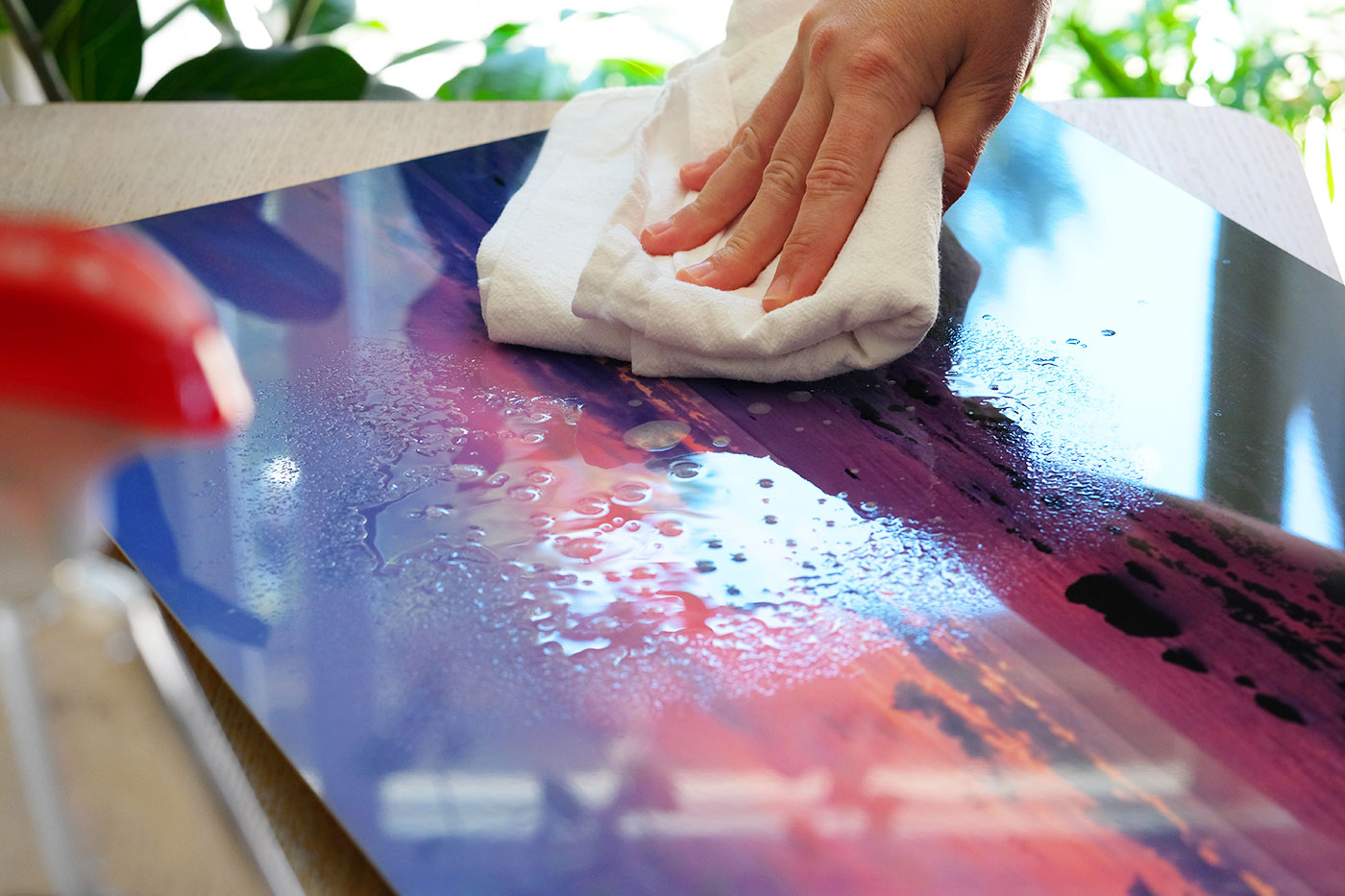 towel in hand wiping liquid cleaner from metalprint