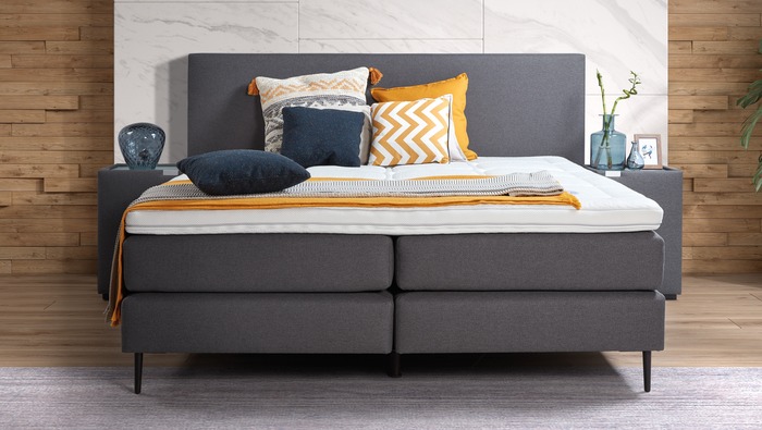 Modern boxspring bed in blauwgrijze stof met hoofdbord en nachttafels