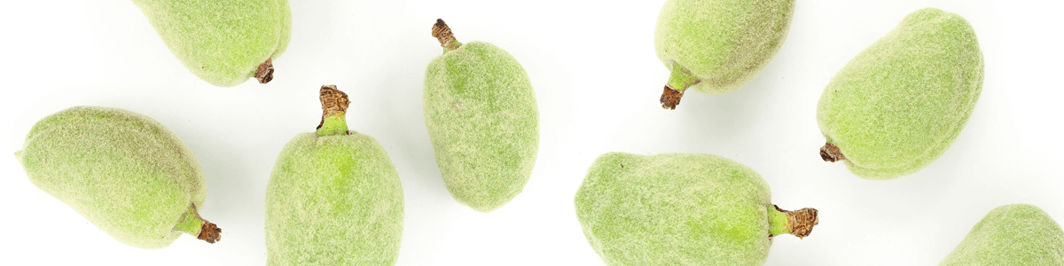 A handful of green almonds on white