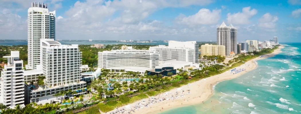 Group Enjoying A Sunny Beach Trip In Miami, Filled With Fun Activities