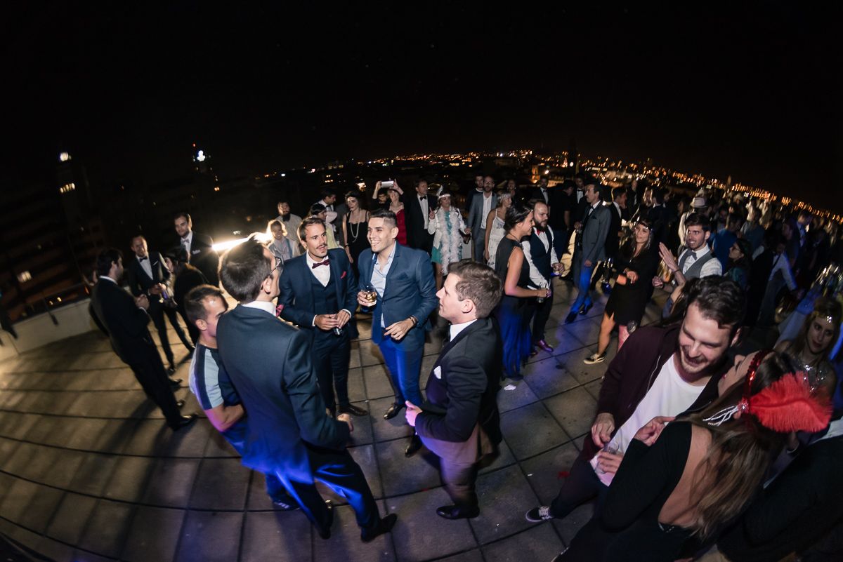 A group of smartly dressed Minders are having a night-time party on the rooftop of the Mindera office. 