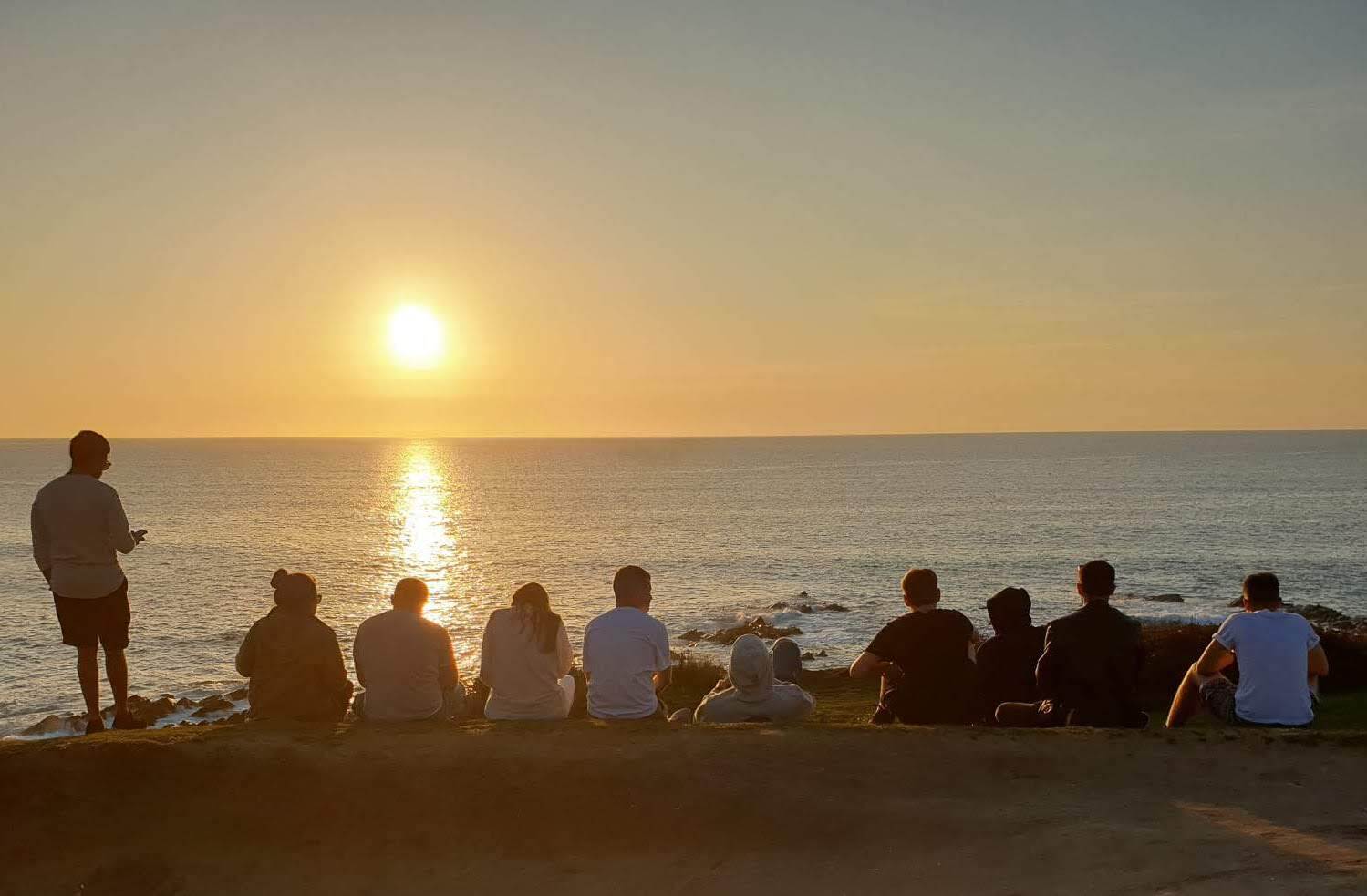 Ten Minders sat on the beach at Newquay are enjoying a sunset. Ten Minders sat on the beach at Newquay are enjoying a sunset.