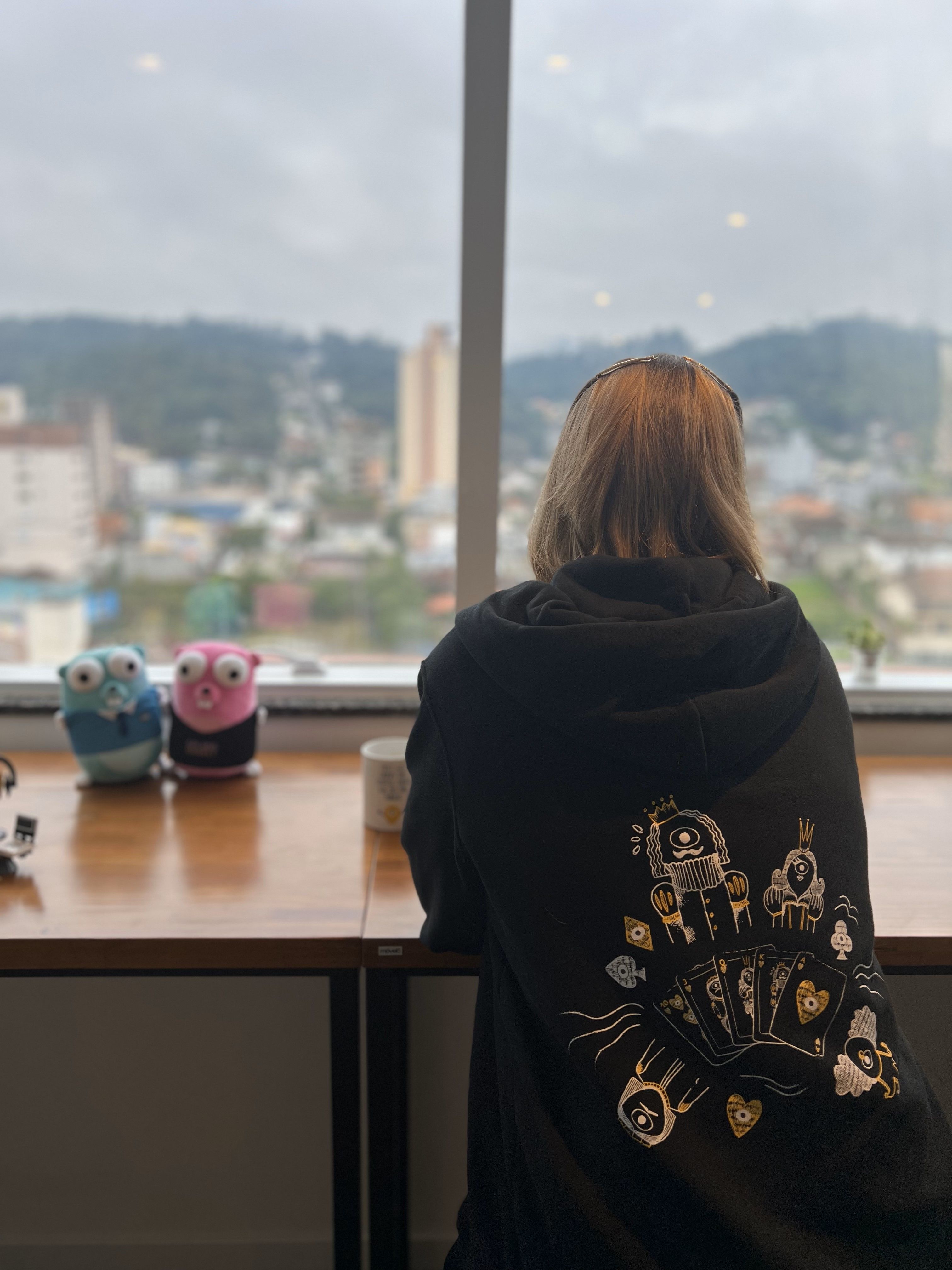 A Minder working in her laptop in front of a window.