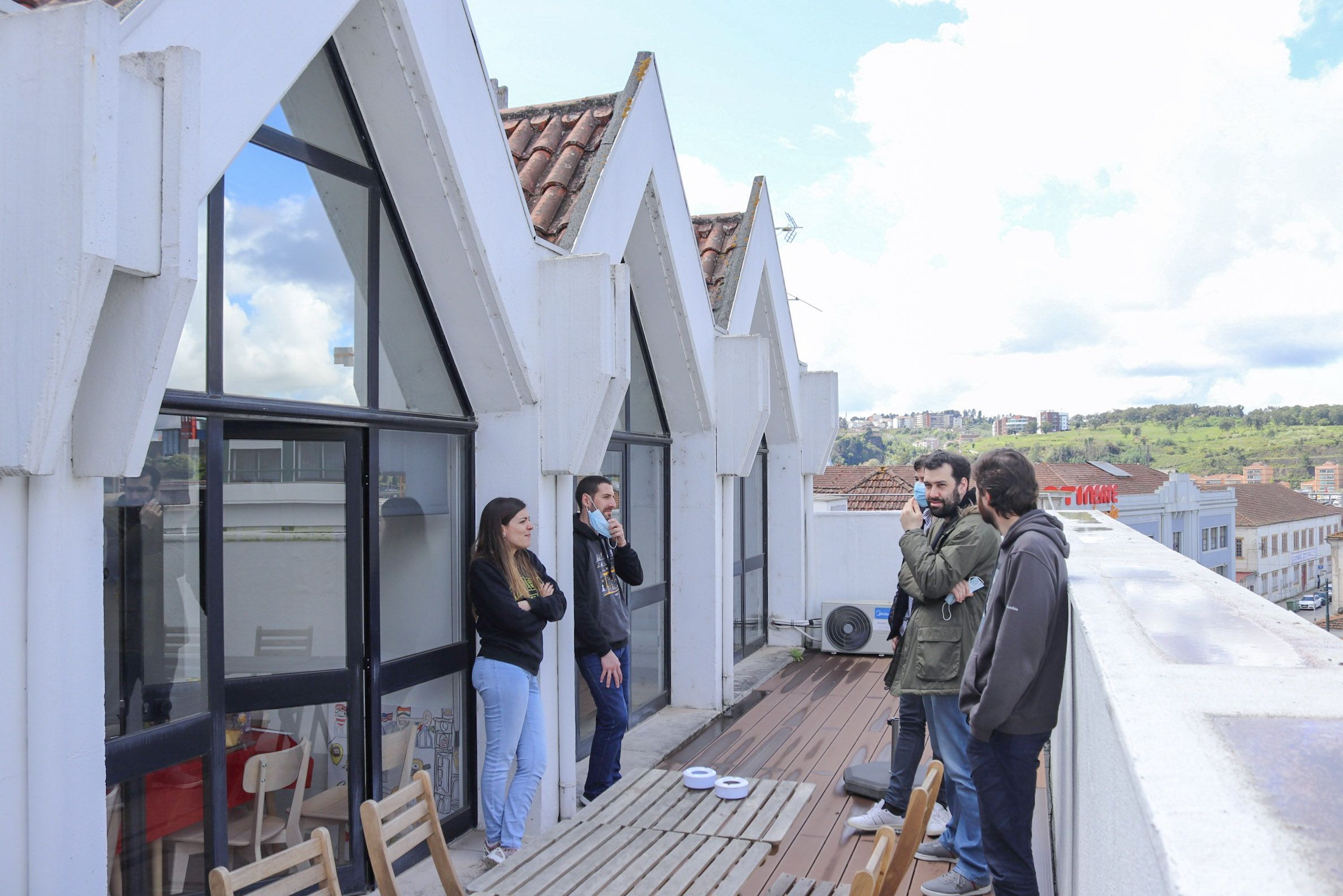 Five Minders stand on the balcony of the Coimbra office of software engineering company Mindera.