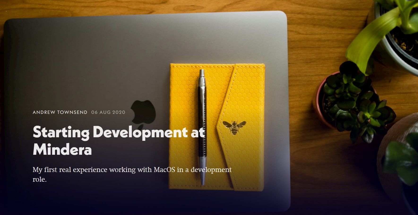 A closed MacBook with a black pen and a yellow writing notepad resting on top of it is used as the featured image for a Mindera blog post.