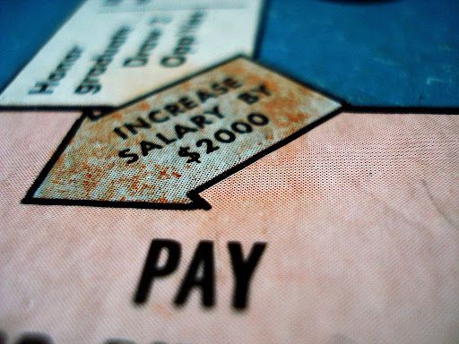 An image of a games board with a arrow saying "increase salary by $2000."