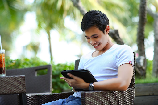 A man holds his tablet and reads a Mindera blog post about why we don't have people managing other people