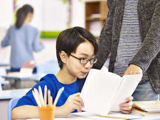 Asian pupil getting help teacher elementary schoolboy tutor classroom school 89652212