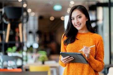 Smart confidence asian female startup entrepreneur small business owner businesswoman wear smart casual cloth smile hand use tablet woking inventory checking showroom office daytime background