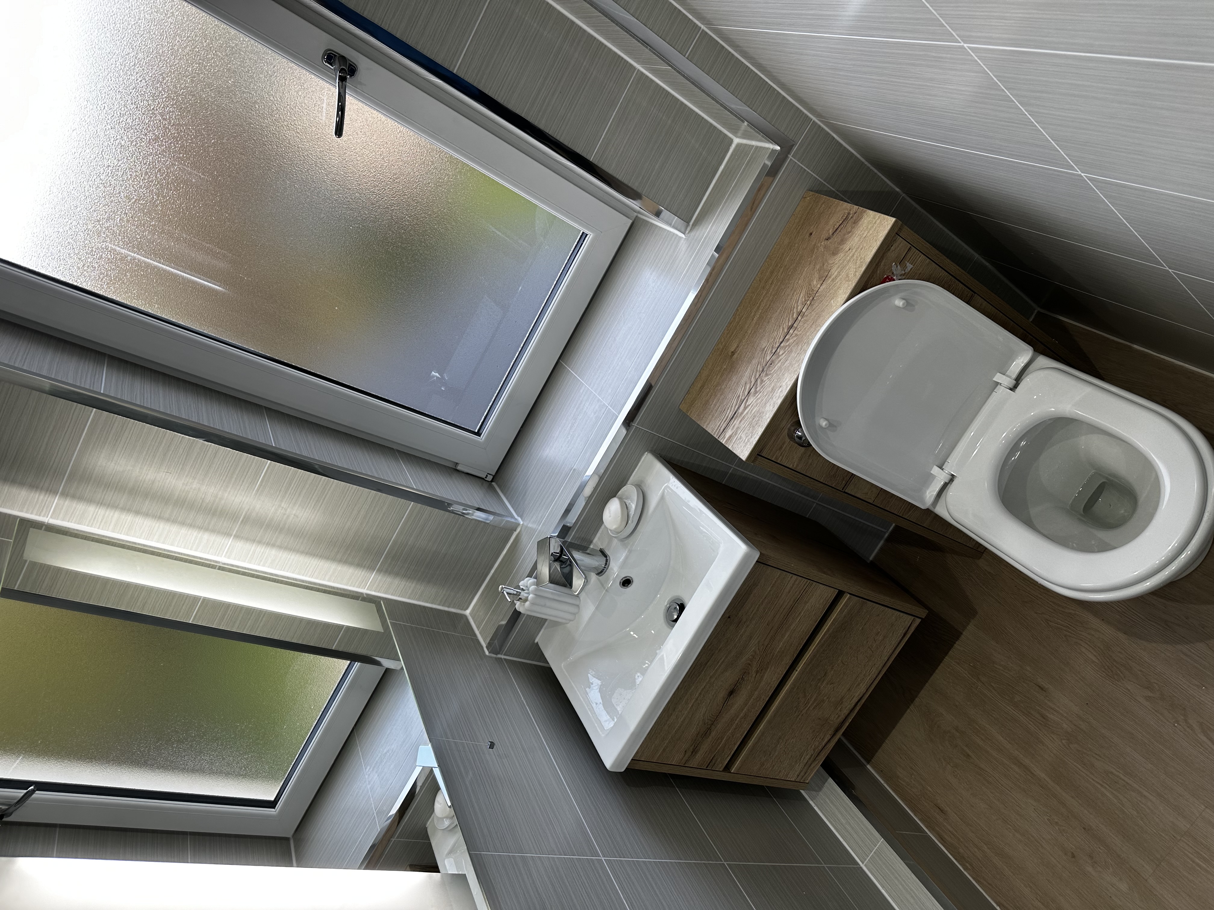 Bright bathroom corner with window, vanity, and toilet.