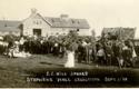 Group of people in front of barn and flag-draped platform, Stephens Hall Dedication, Crookston, Minnesota.