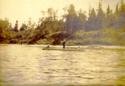 Unidentified men fishing from canoe.