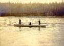 Unidentified men fishing from canoe.