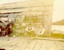 Unidentified men sitting by string of fish, Louis W. Hill, fishing trip.