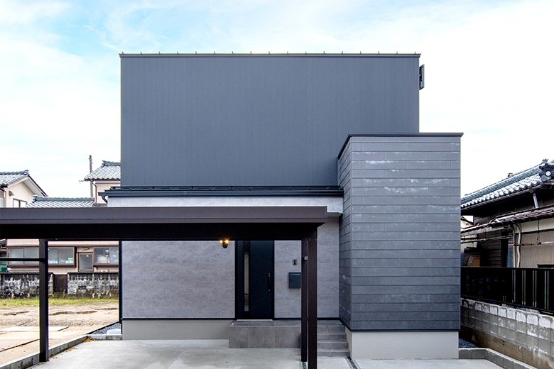 窓のないシンプルなファサード。1階を窯業系、2階を金属系サイディングで変化をつけた