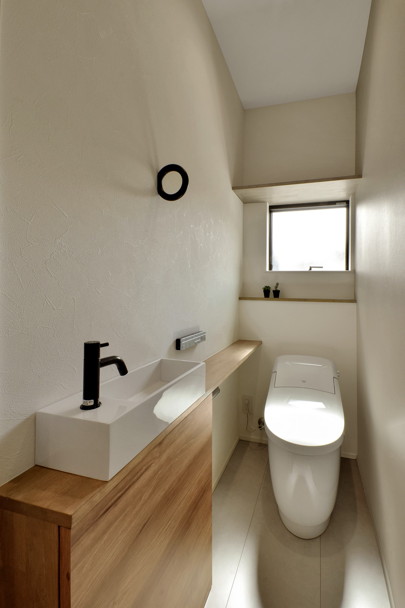 トイレには手洗い器を造作。木目のカウンターがナチュラルな空間を演出