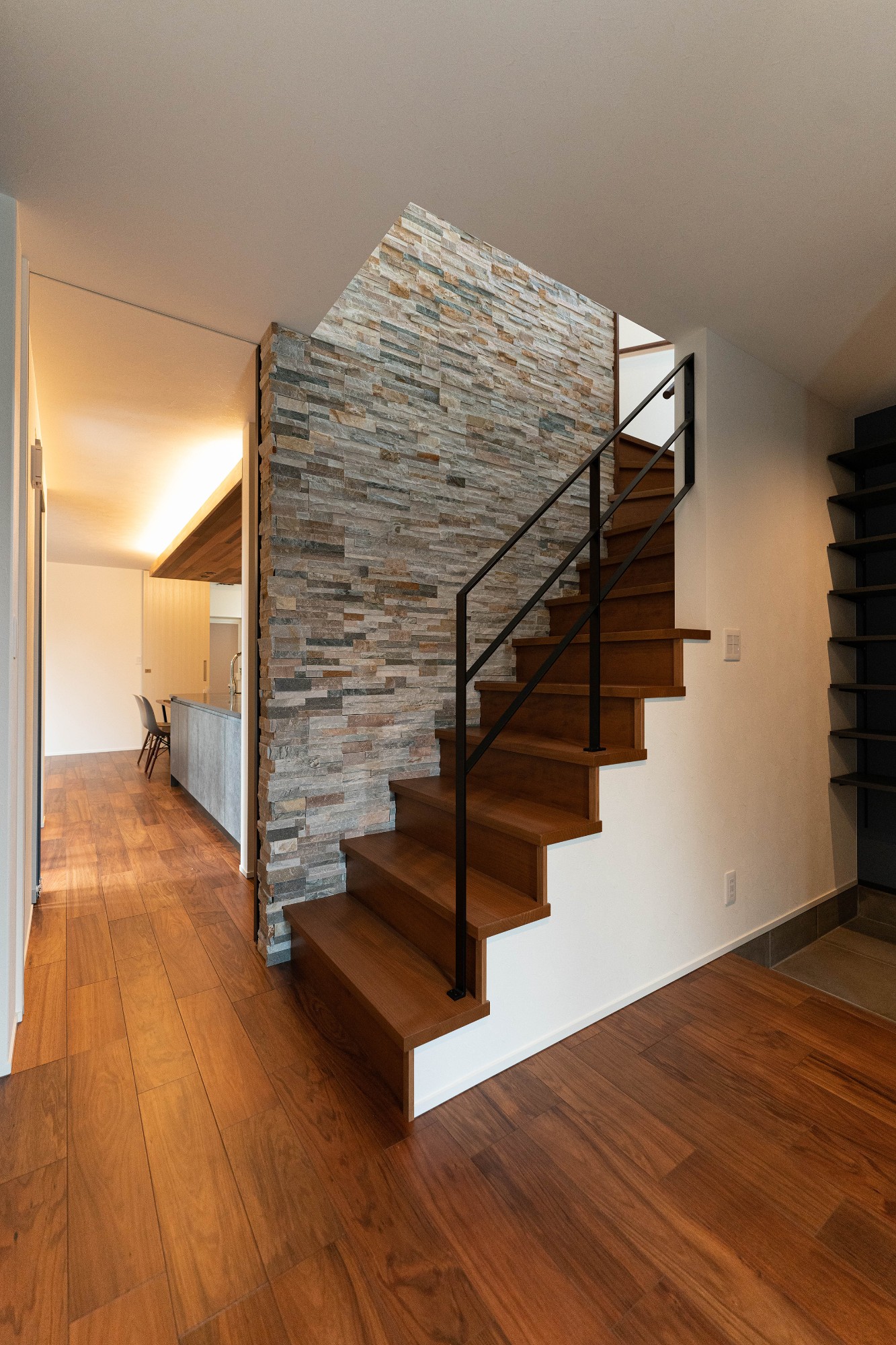 玄関に入ってすぐに目に入る階段ホールには凹凸のある石のタイルを貼り、ブラックの鉄骨手摺を組み合わせて重厚感のある空間に