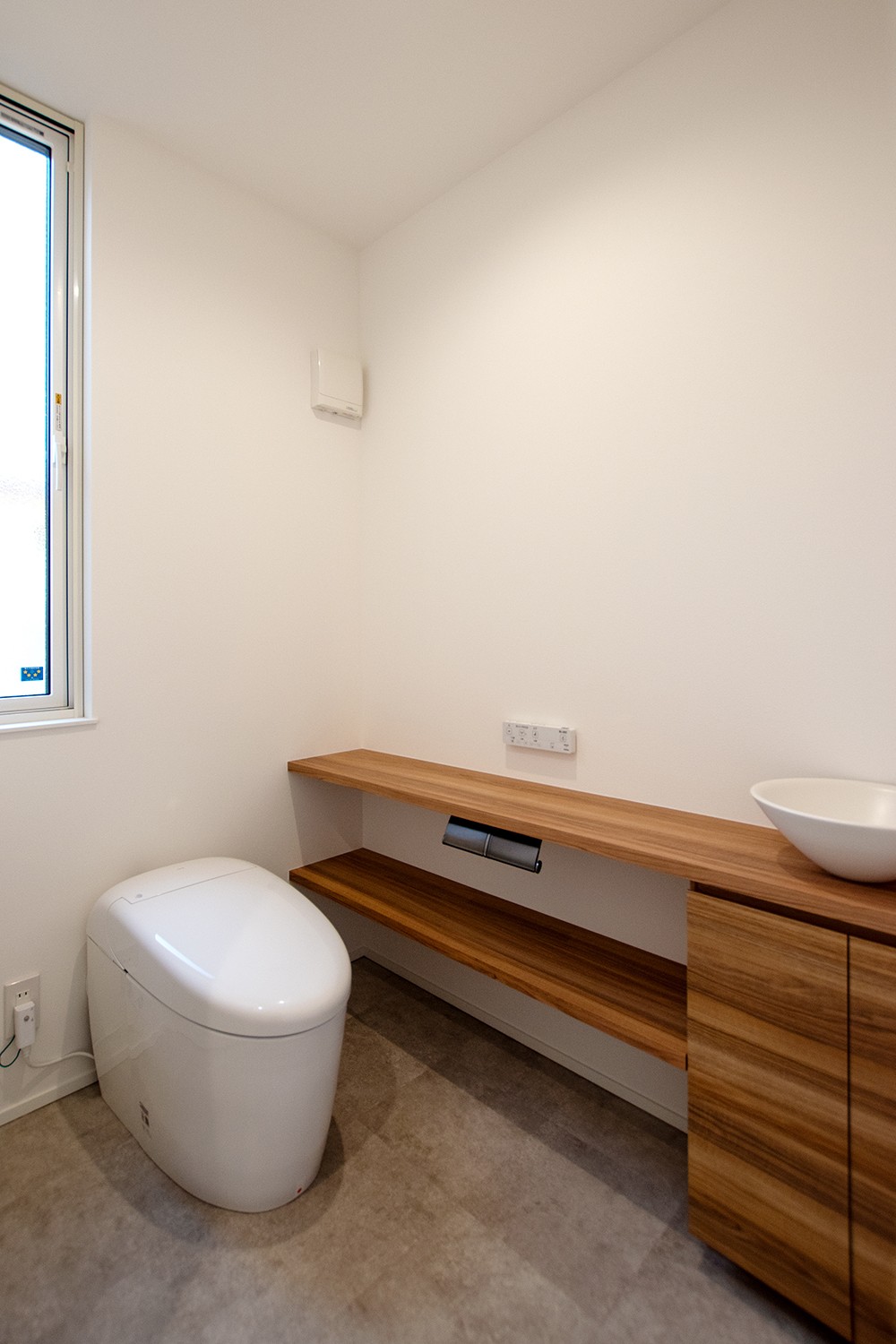 1階のトイレは、手洗いカウンターを造作に変更し、使い勝手とインテリアの統一感を向上。北側にある裏庭から、安定感のある明かりが入る空間とした