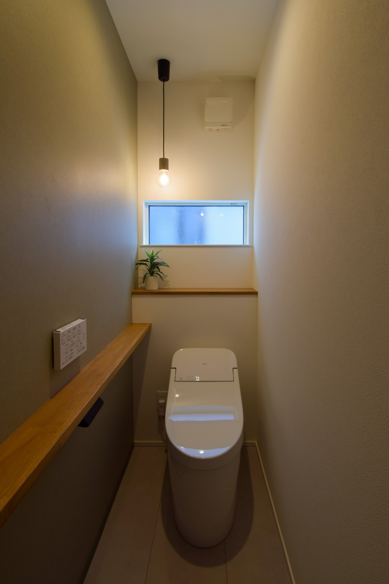 白とグレーと木をベースにトイレを計画。1灯のペンダントライトが落ち着いた雰囲気を醸し出す