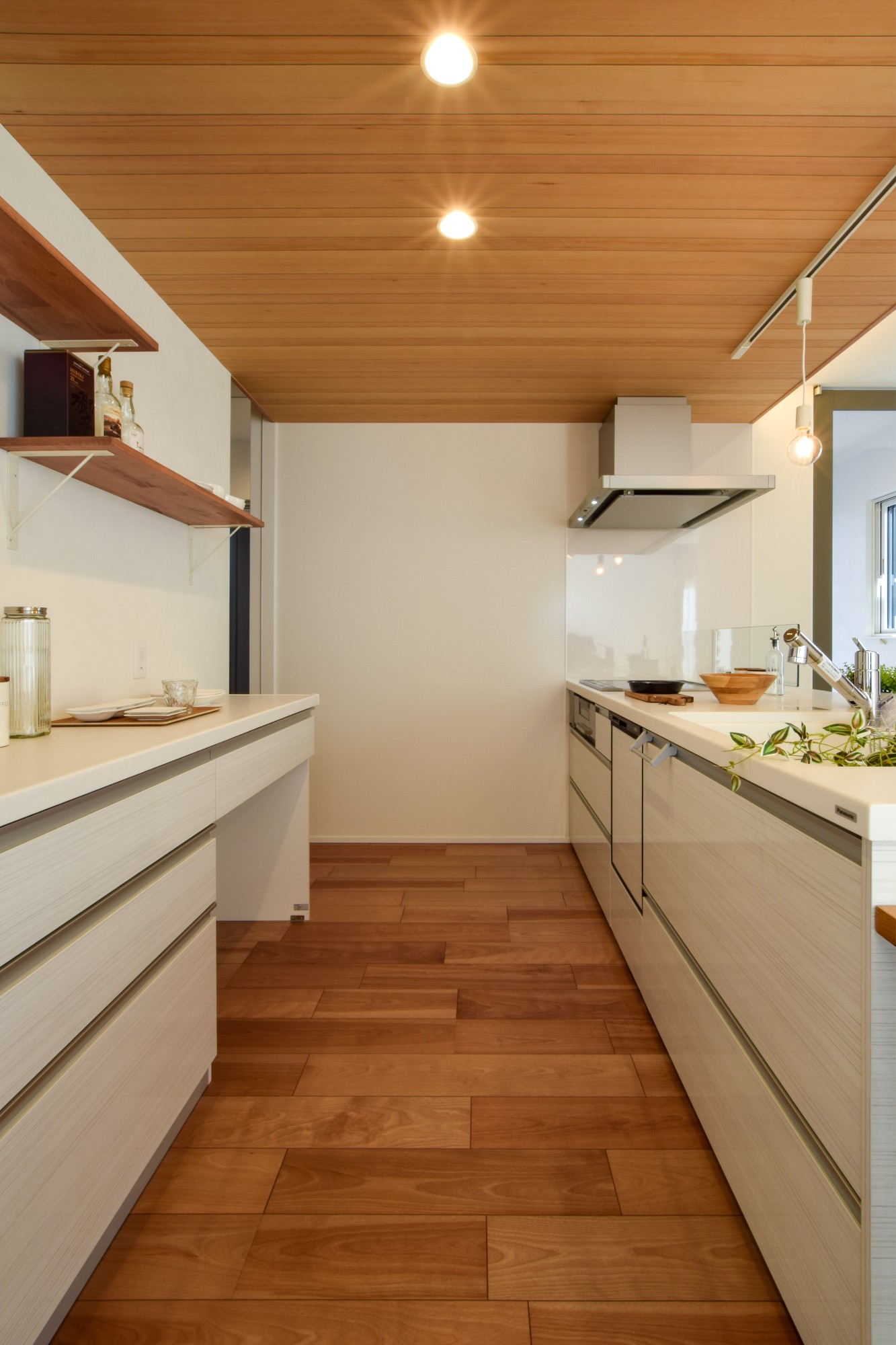 清潔感のある白を基調としたキッチン。キッチン奥からは、パントリー→サンルーム→洗面室→キッチンへとつながる便利な回遊動線。