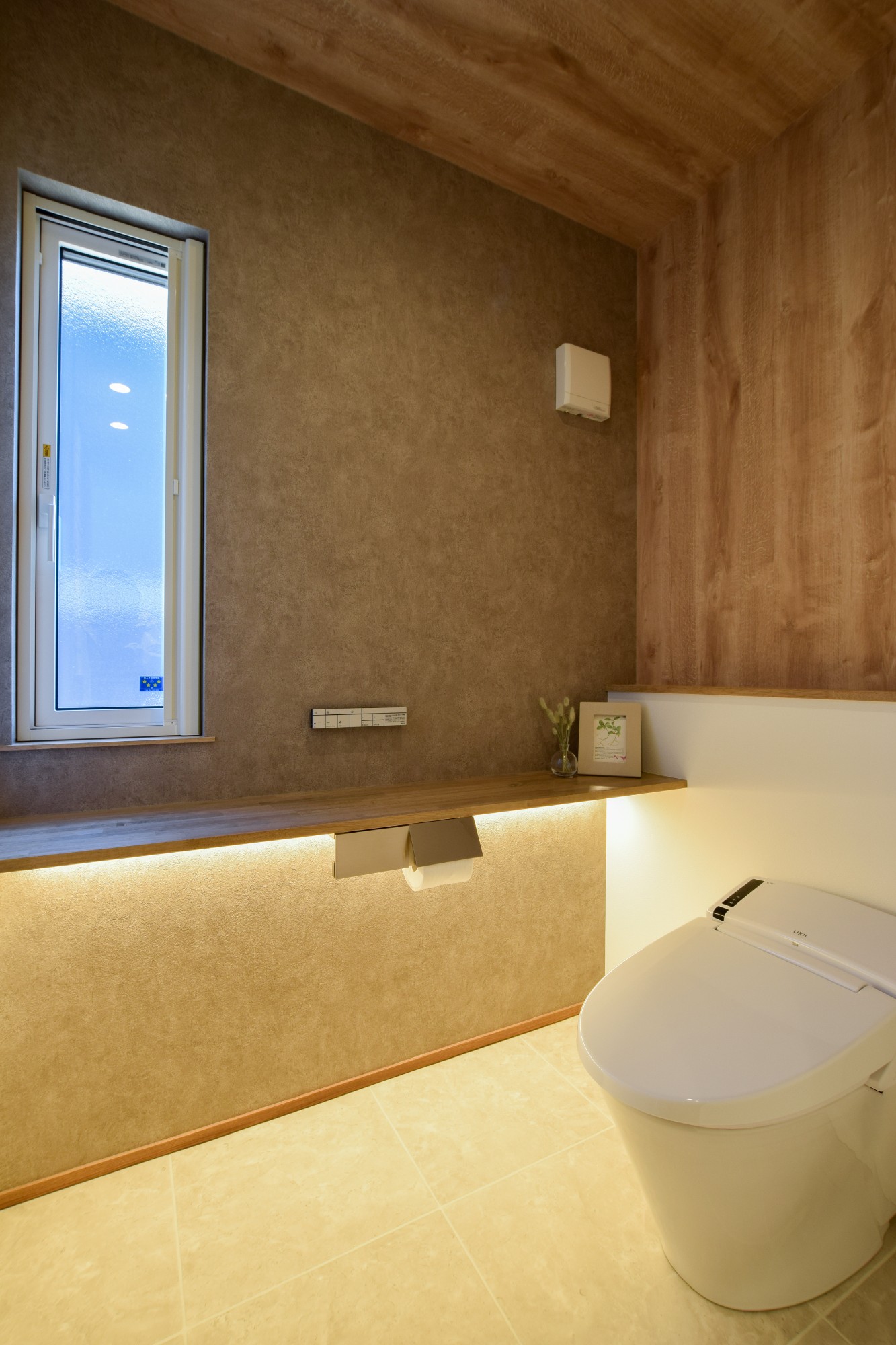 清潔感を持たせながら、落ち着いたトイレ空間にまとめた。カウンター下の照明を採用し、光源を隠しながら明るい印象の空間になっている
