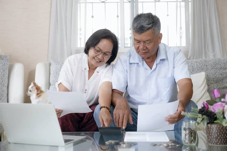 Senior couple discussing finances in front of a computer.