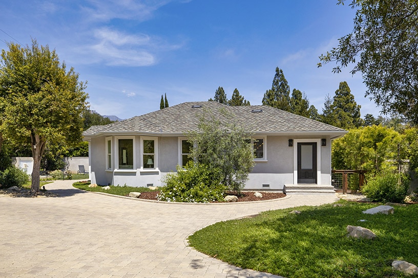 front view of a California cottage with driveway and lawn in the foreground