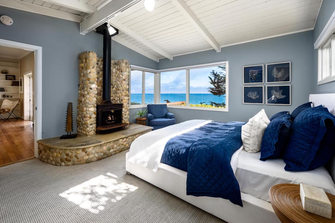 A luxurious bedroom with a fireplace and amazing ocean views. 