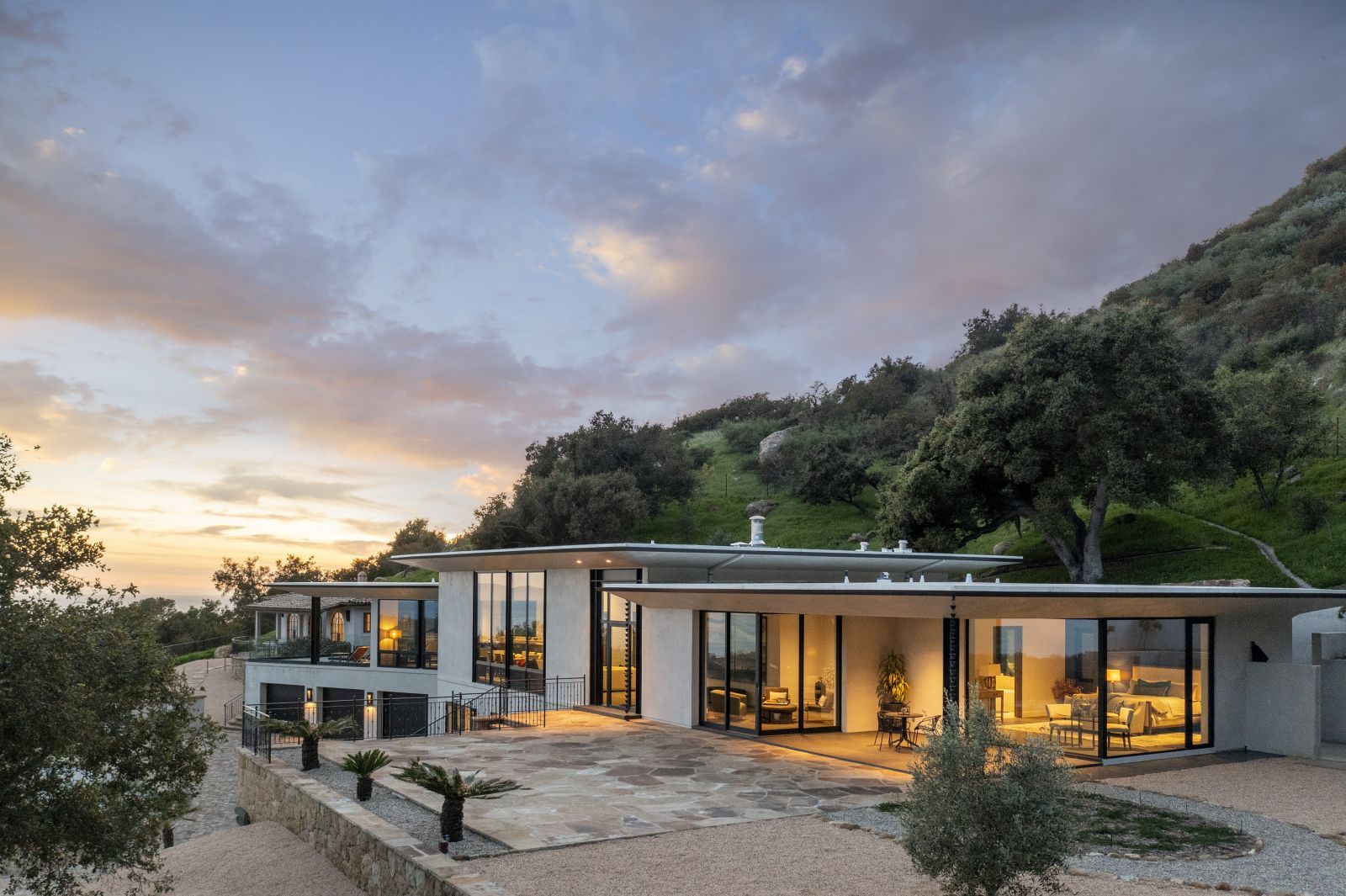 World class contemporary estate against a backdrop of a beautiful twilight sky and lush greenery