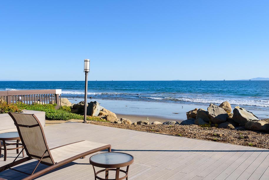 The sundeck of a condo in Santa Barbara County with lounge and table looking out to the beach