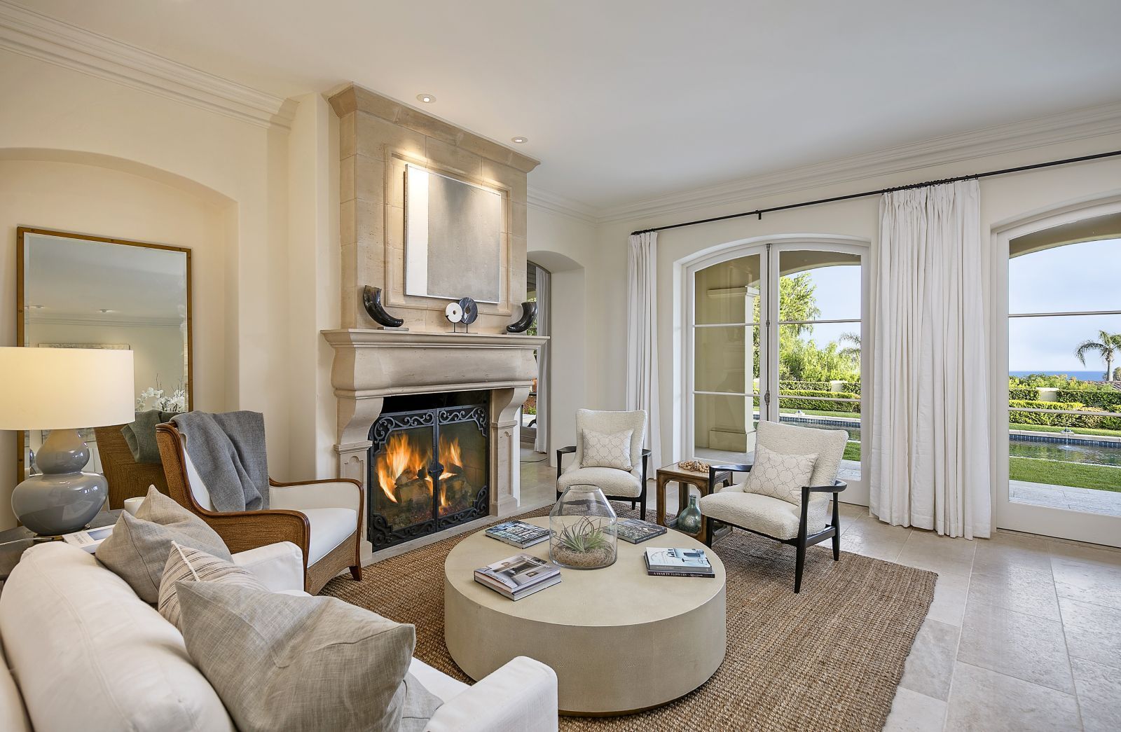 The living room of a luxury home with a fire in the fireplace