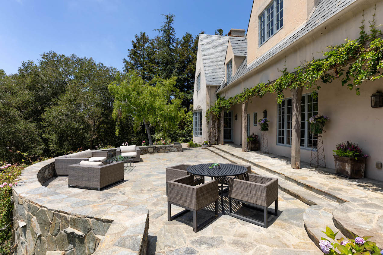 The backyard deck complete with chairs and table for outside dining at a luxury estate surrounded by mother nature