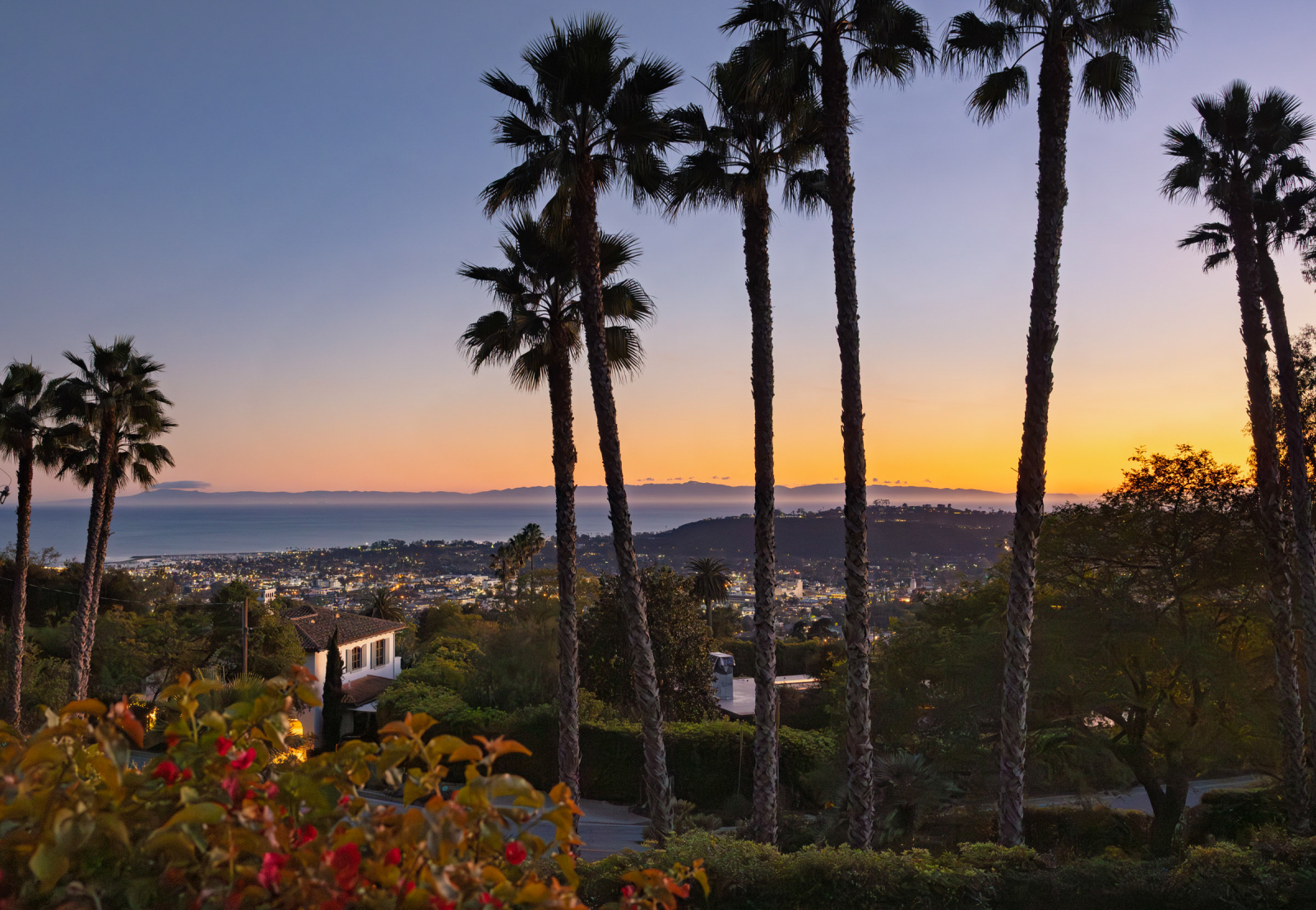 Sunset over the Pacific Ocean from the balcony of a Santa Barbara home with majestic palm trees.